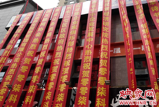 路邊一棟樓上懸掛著二三十條紅色條幅，全部是祝賀一家公司開業(yè)的。