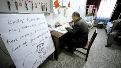 張大爺在門(mén)衛(wèi)室里工作，旁邊是紅爆網(wǎng)絡(luò)的溫馨提示牌記者