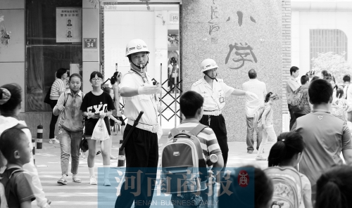 伊河路小學(xué)門口，兩名巡防隊(duì)員護(hù)送學(xué)生過馬路