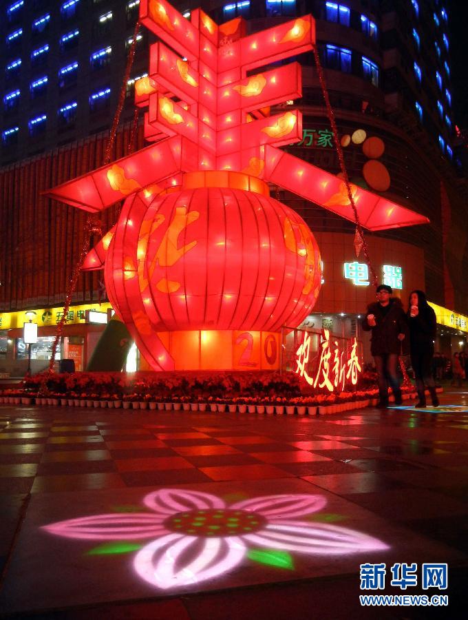 　1月30日晚，市民從蘇州市石路銀河廣場(chǎng)上大型“春”字彩燈景觀旁經(jīng)過(guò)。
