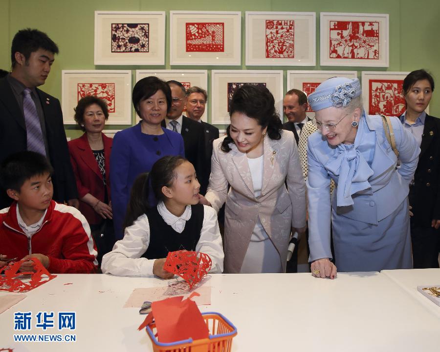 這是彭麗媛和瑪格麗特二世與根據(jù)安徒生童話中人物和情節(jié)制作剪紙的孩子交談。
