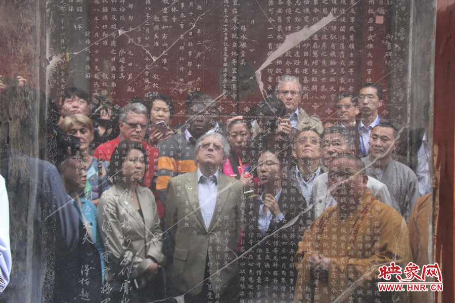在一塊石碑前，少林寺方丈正在講解