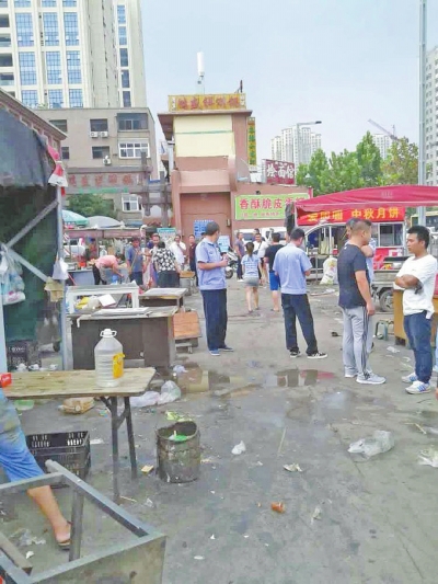 昨天，執(zhí)法人員在京廣路長(zhǎng)江路口整治“僵尸圍擋”及圍擋內(nèi)的攤販。