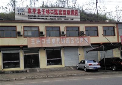 4月23日，王林口煤炭營(yíng)銷園區(qū)招商部窗上還貼著“河北省阜平縣重點(diǎn)工程”的宣傳貼。新京報(bào)記者 張永生 攝
