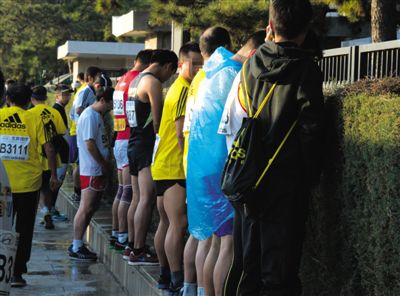 2013年10月20日，北京馬拉松比賽，由于廁位有限，一些選手在綠化帶“就地解決”。圖/IC