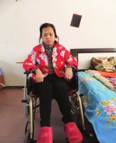 陳慶霞坐在輪椅上。她現(xiàn)在下身癱瘓，疾病纏身，生活不能自理。