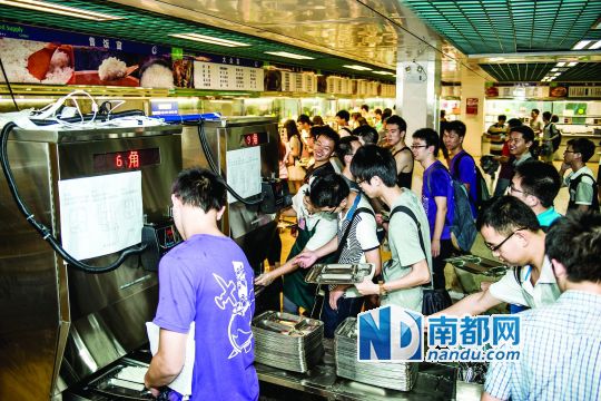 昨日，華南理工大學一食堂內(nèi)，學生們正在使用新安裝的自動打飯機打飯。中新社發(fā)