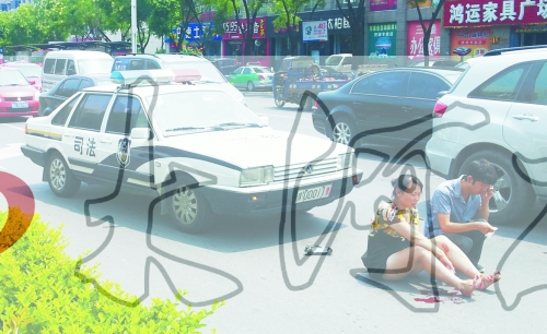 事故發(fā)生后，警車司機(jī)（右）下車查看傷者并撥打120，倆“領(lǐng)導(dǎo)”穩(wěn)坐車內(nèi)引發(fā)圍觀者不滿。