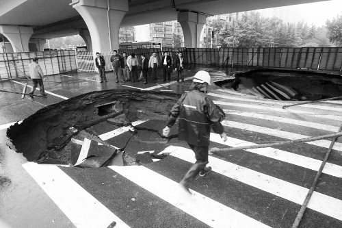 中原路西三環(huán)立交橋下由南向北原本4個(gè)車(chē)道，由于塌坑，而今3個(gè)車(chē)道被圍擋