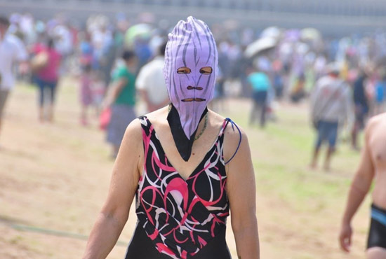 2013年7月3日，山東青島青島高溫來襲，“青島大媽”不懼滸苔，戴著“強盜面具”出現在海水浴場消暑降