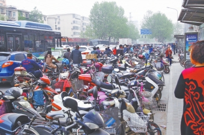 省人民醫(yī)院北門，路邊的公交站牌處停滿非機動車，上、下客只能在快車道上。