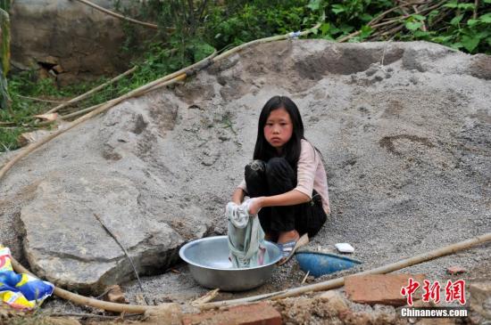 8月9日，云南巧家紅石巖村，10歲的劉鑫蕊在洗自己的衣服