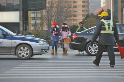 過(guò)斑馬線，行人左顧右盼，汽車(chē)寸土必爭(zhēng)。