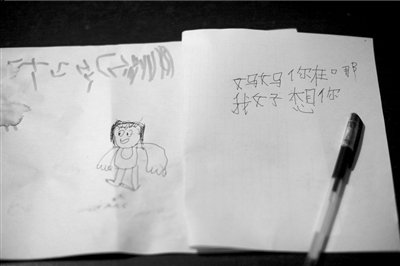 名叫袁明燕的小姑娘用筆在紙上不斷寫“媽媽”二字。