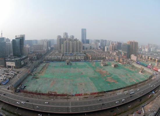2016年4月，經(jīng)過持續(xù)攻堅，親賢社區(qū)西北片區(qū)的拆遷工作基本告一段落，但在鋪設(shè)了防塵綠網(wǎng)的空地中，至今仍有3戶居民選擇了“堅守”。(拍攝：2016年4月4日)