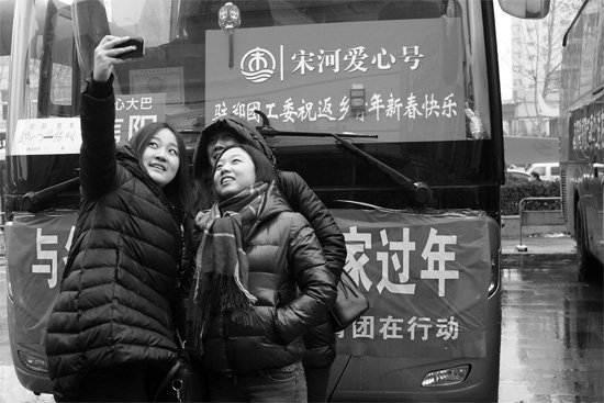 昨天上午8時(shí)，鄭州正道中環(huán)百貨廣場(chǎng)，準(zhǔn)備回家的老鄉(xiāng)在愛(ài)心大巴車前合影留念