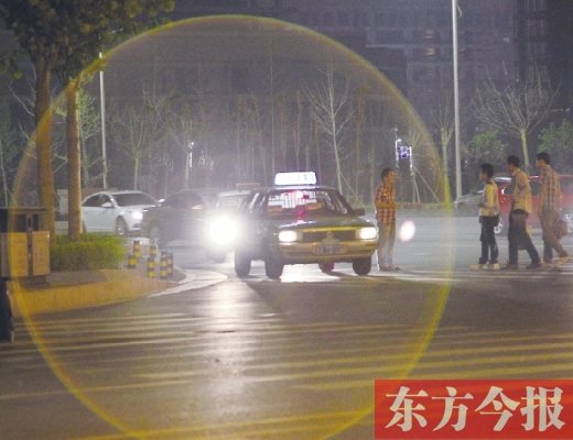 昨晚，鄭州火車東站，一些出租車停靠在路邊，見到行人不時主動搭訕 東方今報暗訪組 攝