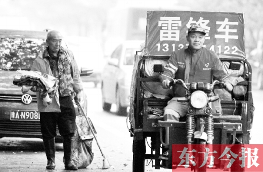 鄭州市商城路，一名環(huán)衛(wèi)工懷抱著剛剛收到的毯子，目送“雷鋒哥”孫德坤離開