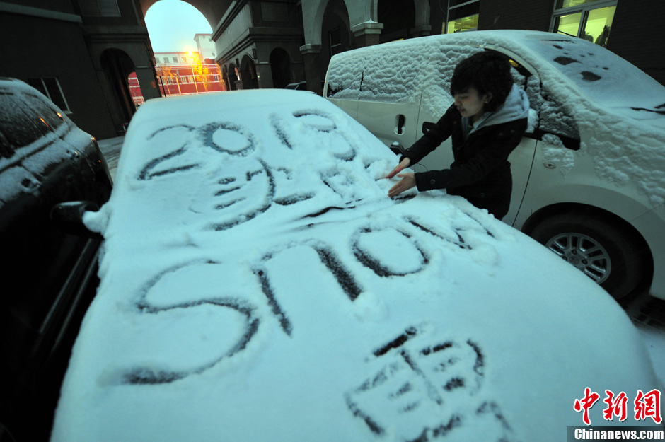 11月18日，行人在車輛的積雪上涂鴉。