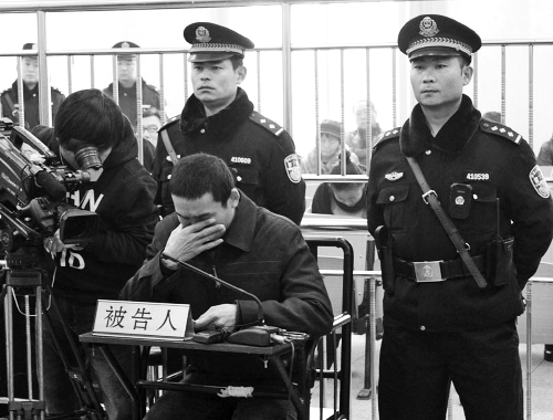 庭審中,29歲的李軍低著頭。