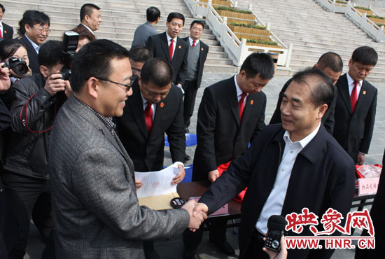在新密市法院，省高院院長張立勇為拍得轎車的陳先生發(fā)放車鑰匙。