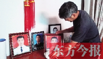 沉浸在悲痛之中的魯有海，擦拭著孩子的遺照