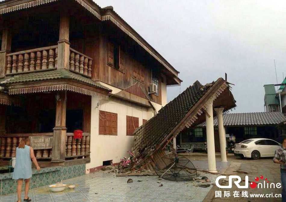 當?shù)貢r間2014年5月5日，泰國清萊，一名婦女看著受損的房屋。 圖片來源：東方IC