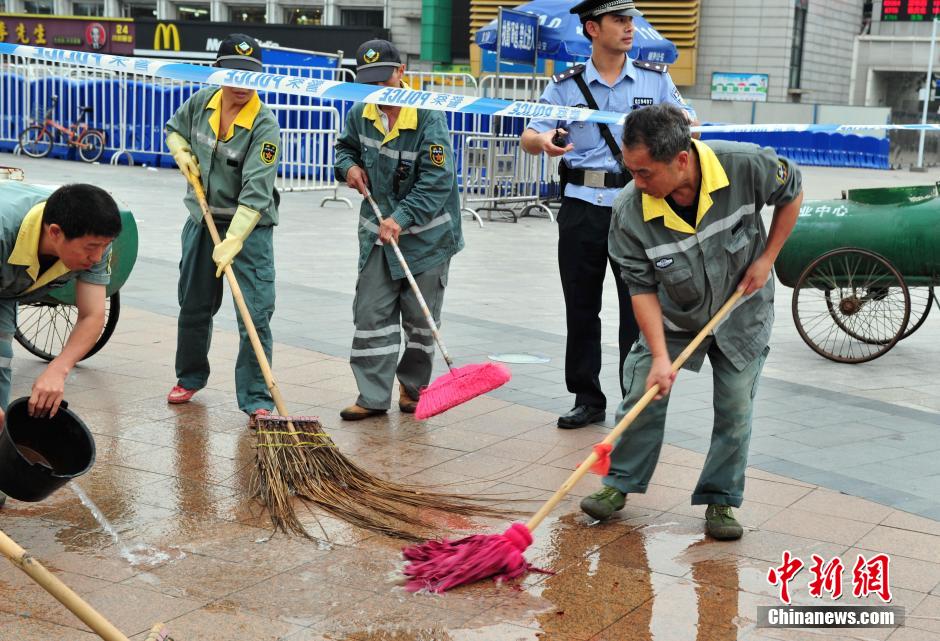 圖為環(huán)衛(wèi)工人在清理案發(fā)地點(diǎn)的血跡。
