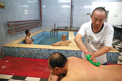 客人在搓澡。近日，百年歷史的鑫園浴池宣布將關(guān)張。新京報(bào)記者