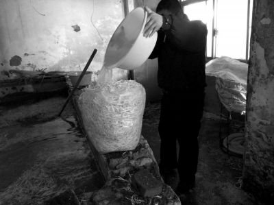 作坊內(nèi)工人用攪拌有漂白粉的藥水給豆芽增白。