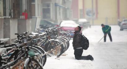 小伙子跪在樓前，一直抬頭看著樓上。 孫立國/攝
