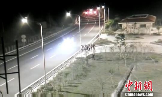 看到車輛經(jīng)過，孩子們便急忙跑到一旁的花圃上?！【焦﹫D　攝