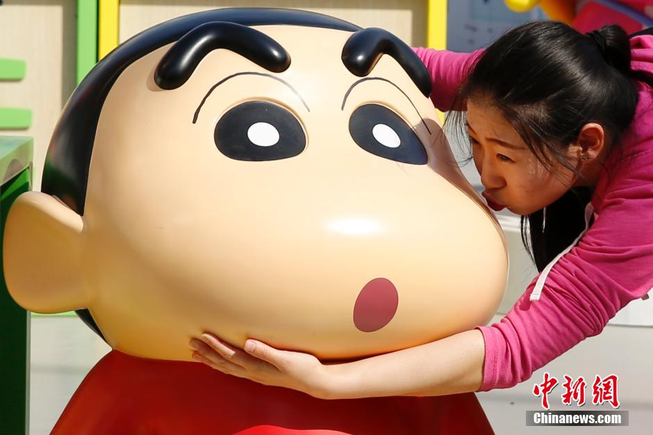 4月22日，游客與蠟筆小新合影?！跋灩P小新25周年紀(jì)念特展”日前在北京開展，吸引了不少市民游客。