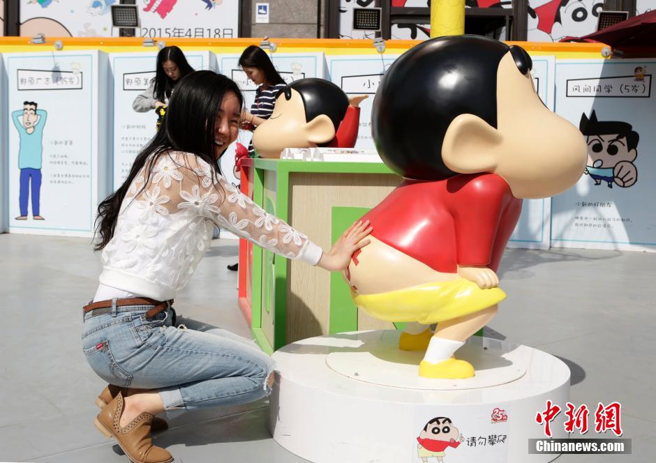 4月22日，游客與蠟筆小新合影?！跋灩P小新25周年紀(jì)念特展”日前在北京開展，吸引了不少市民游客。