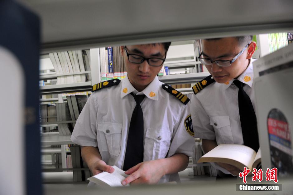 5月8日，武漢輕工大學(xué)圖書館保安吳濤與江力在圖書館交流學(xué)習(xí)。