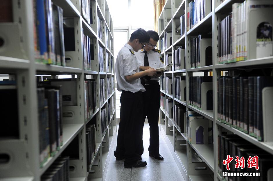 5月8日，武漢輕工大學(xué)保安吳濤與江力在圖書館交流學(xué)習(xí)。中新社發(fā) 張暢 攝