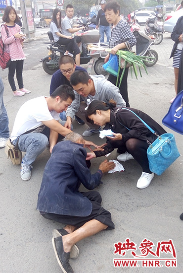 一些愛(ài)心市民在撥打了110和120后，上前給老人擦臉上的血跡。