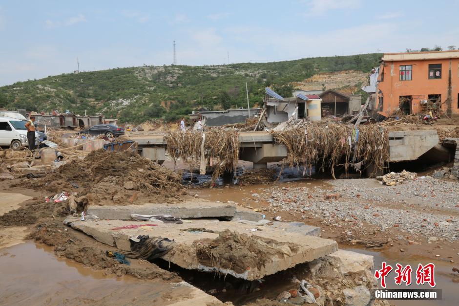 圖為洪水過后，坍塌的橋梁上遺落大量雜草。