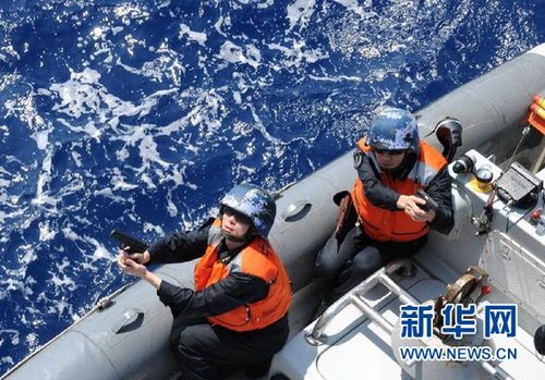　3月28日，十余名臨檢拿捕隊員乘小艇駛至模擬可疑商船下方水面。