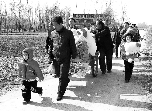 姐（左一）弟（右一護(hù)士懷中男嬰）返鄉(xiāng)，愛心捐贈滿滿一架子車。