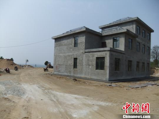 鴨河水庫(kù)庫(kù)區(qū)邊的新建別墅，一面墻上寫著“拆”，另一邊在加緊施工。吳揚(yáng)　攝